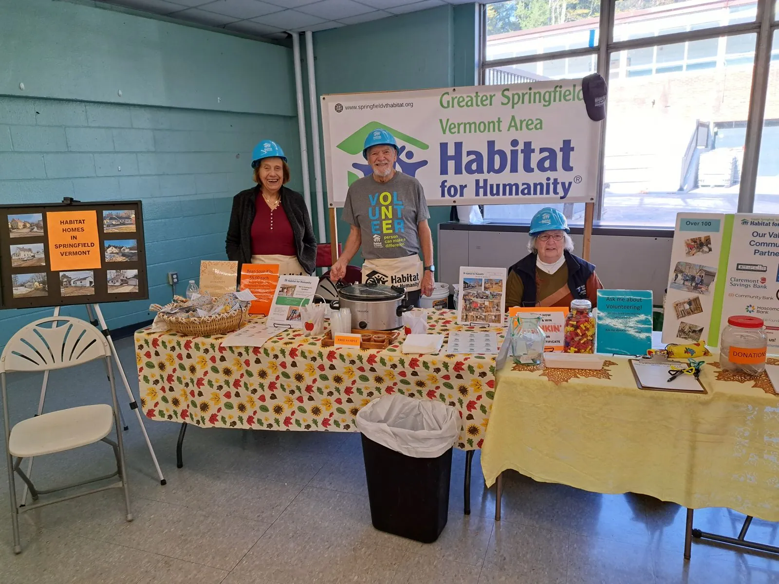 Volunteers greeting visitors at a Habitat information table during a community event