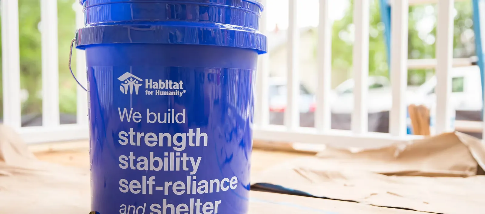 Habitat-branded bucket reading 'We build strength, stability, self-reliance and shelter'