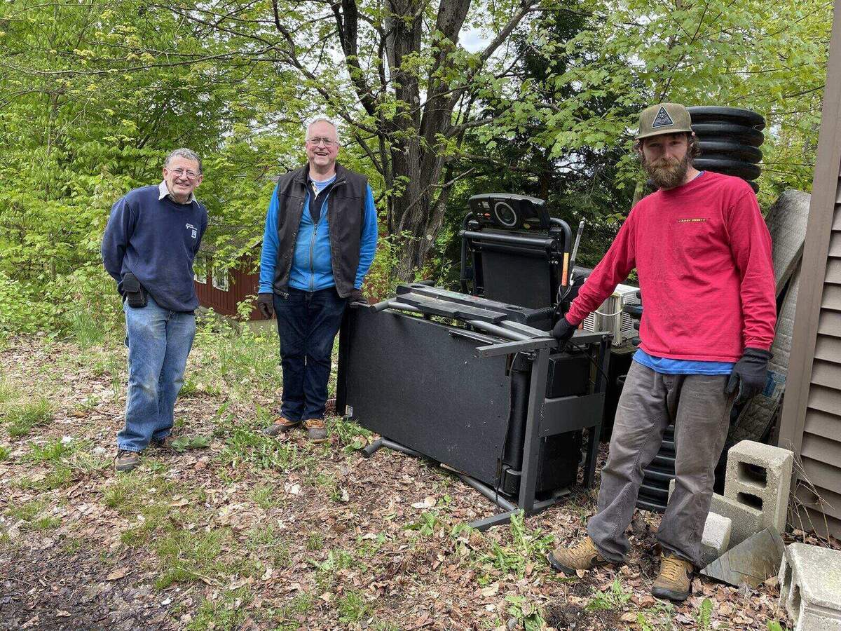 Volunteers sorting discarded appliances and equipment during a site cleanup